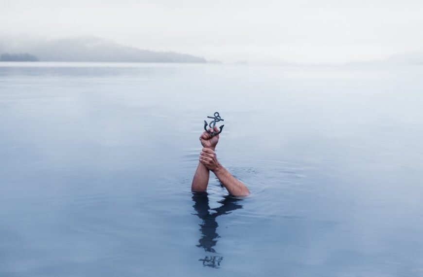 a person holding an anchor above the water