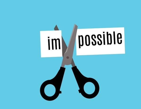 scissors cutting the 'im' off of the word 'impossible'