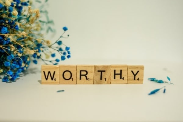 the word 'worthy' written with Scrabble tiles