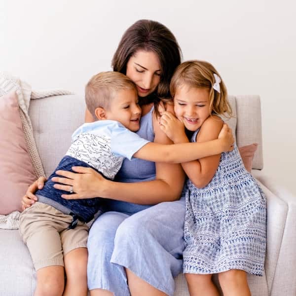 a mother hugging her children
