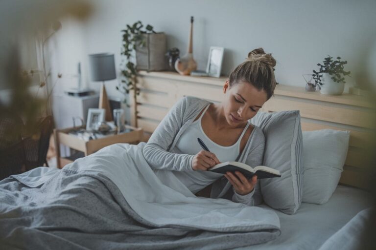 a woman using nightly journal prompts before bed