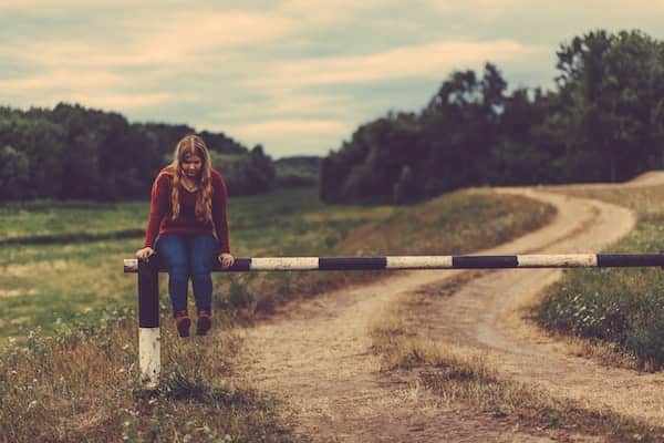 girl sitting on a barrier