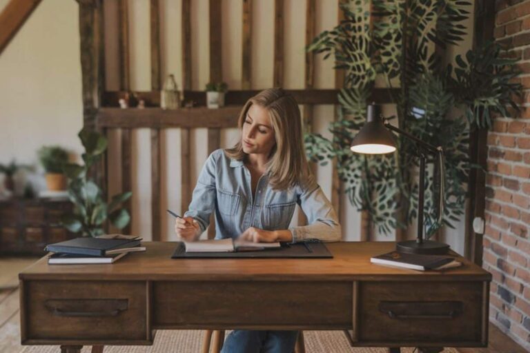 woman sitting at desk with a journal