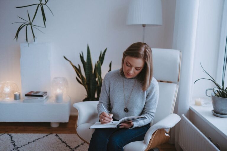a woman writing in a self discovery journal